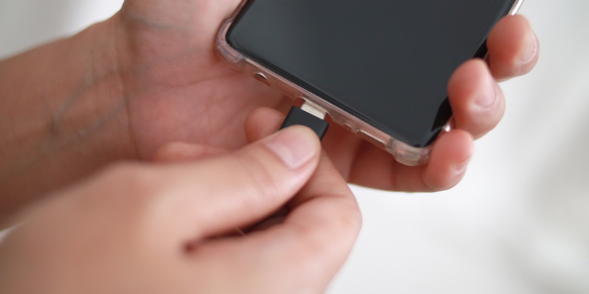 Kabel USB-C wetknięty w port ładowania smartfona
